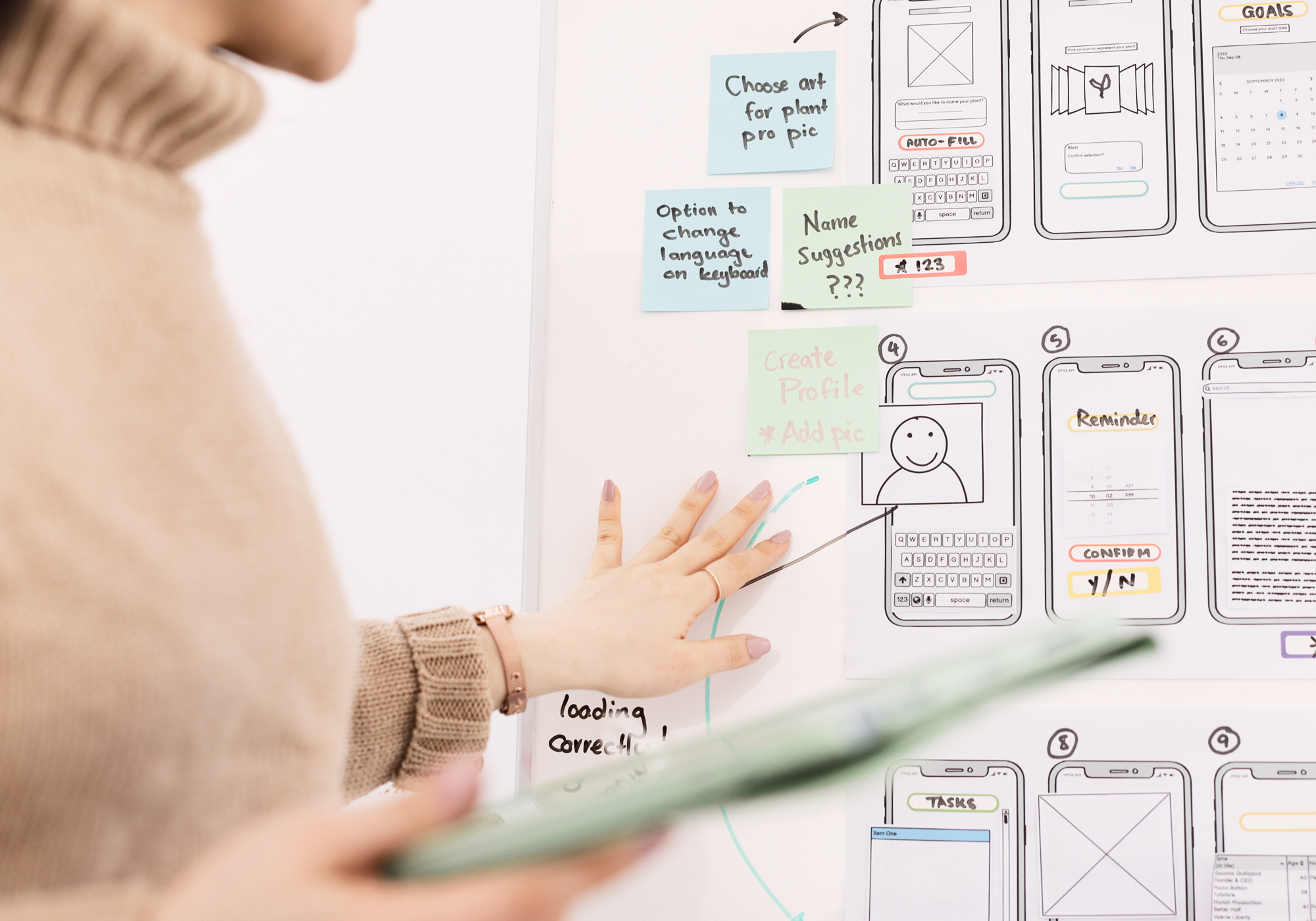 Designer next to a board with wireframes.