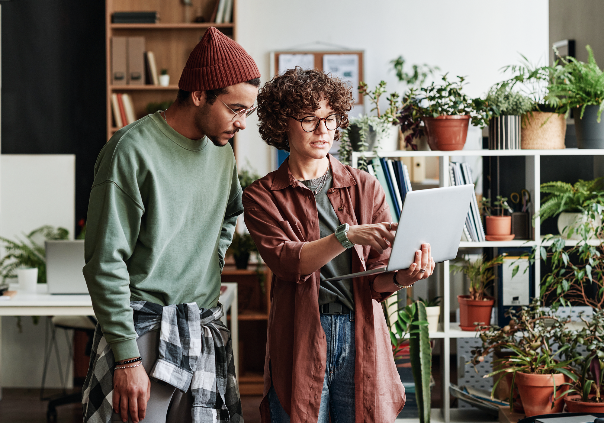 A pair of young people looking at a laptop together.